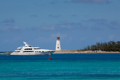 Luxury yatch passing the lighthouse on the island of Nassau in the Bahamas