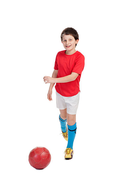 istock boy kicking a red soccer ball 177280297