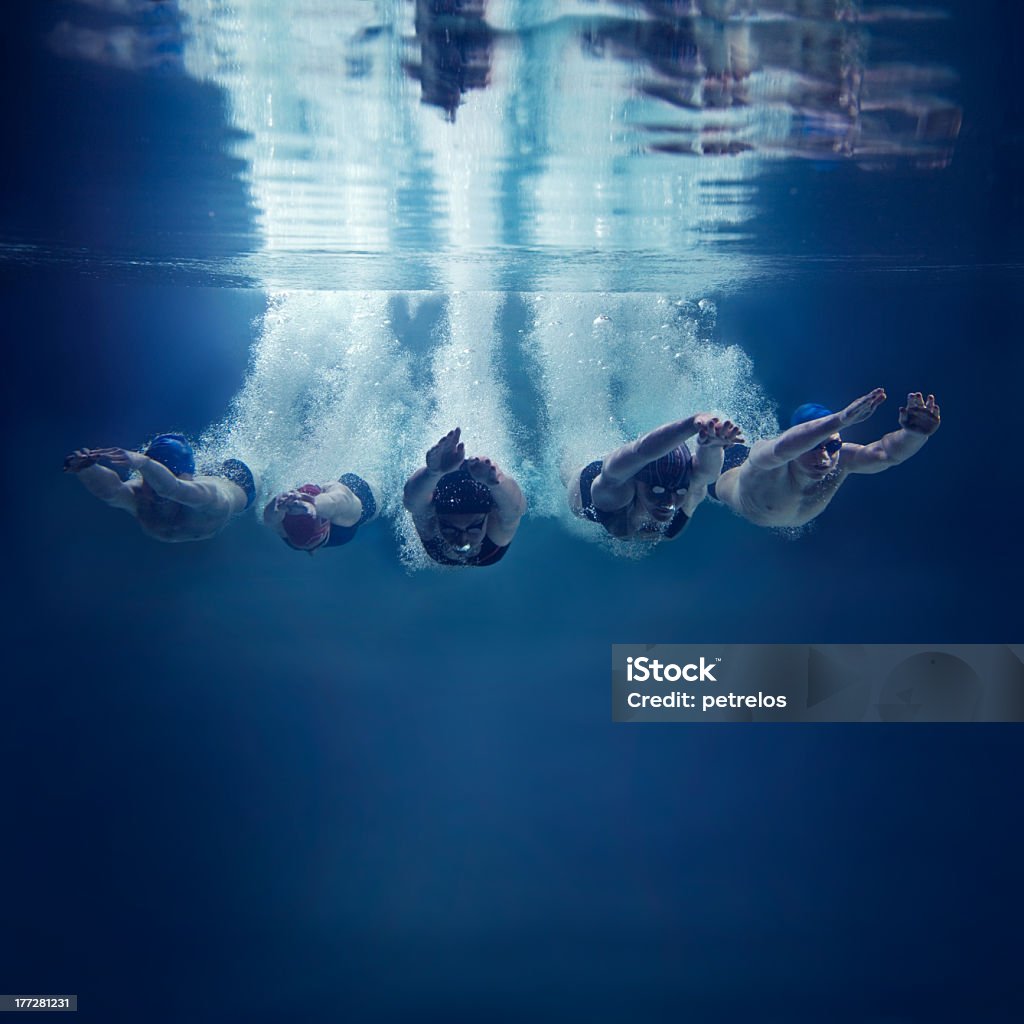 Cinco nadadores pulando juntos na água, Vista debaixo d'água - Foto de stock de Natação royalty-free