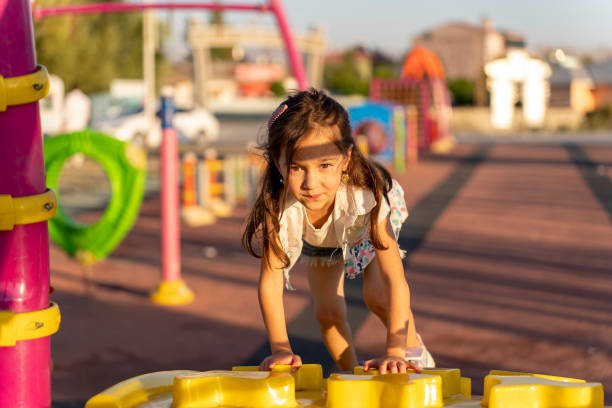 Funny and Cute girl child portrait looking at camera through a blue circle toy smiling