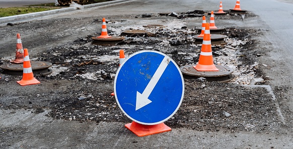 road sign a white arrow on a blue background indicates the path, road works, detour of a dangerous section of road, repair of the roadbed