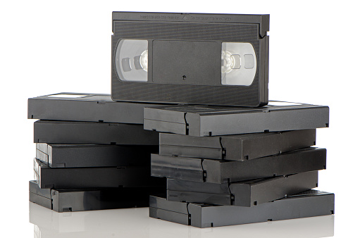 Pile of videotapes on  white reflective background.