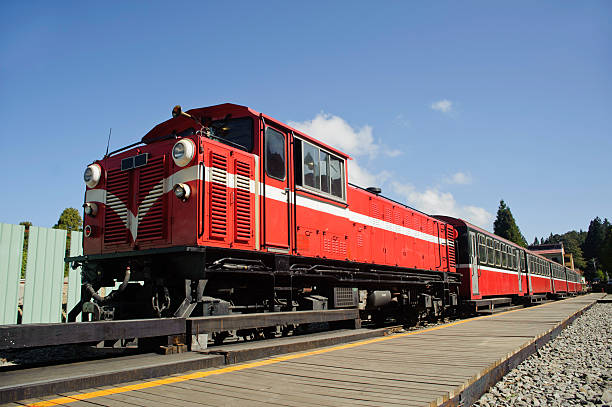 red train under blue sky on railway forest in Taiwan. stock photo