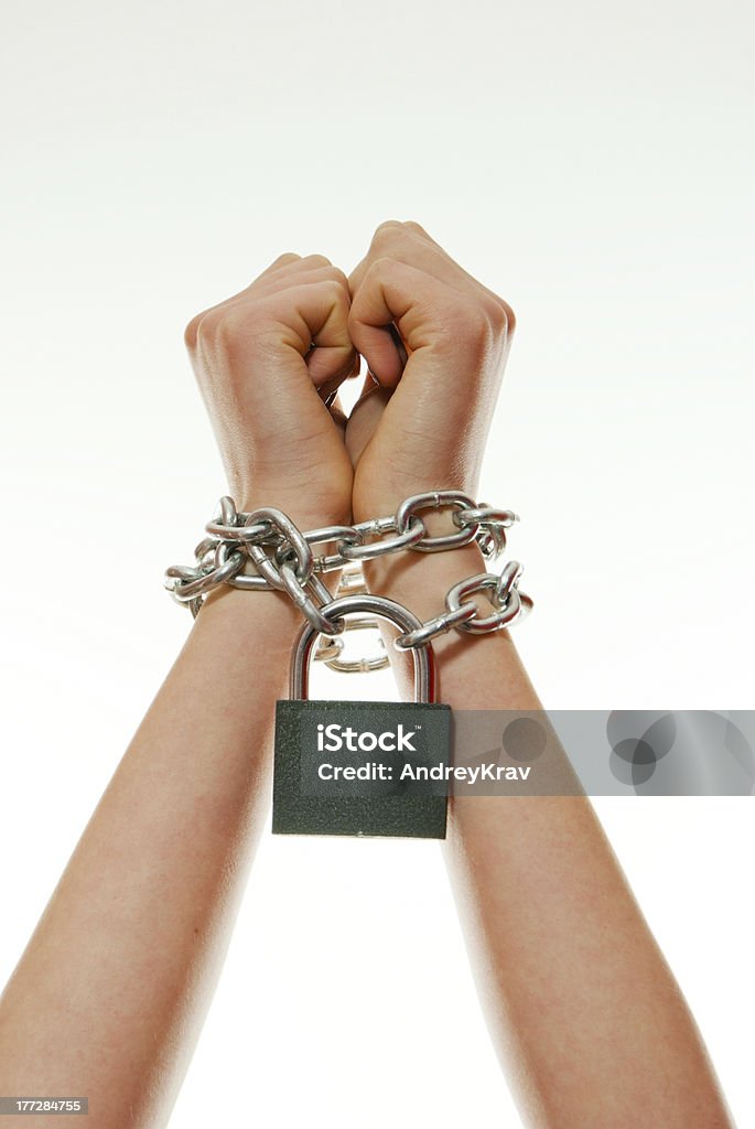 Hands tied up with chains Woman's hands tied up with chains against light background Modern Slavery Stock Photo