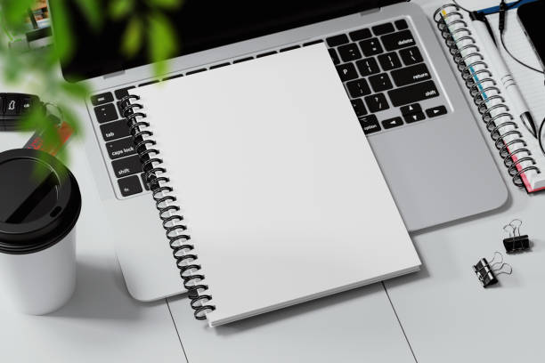 istock Spiral bound book on a laptop keyboard mockup. 3D rendering 1772868428