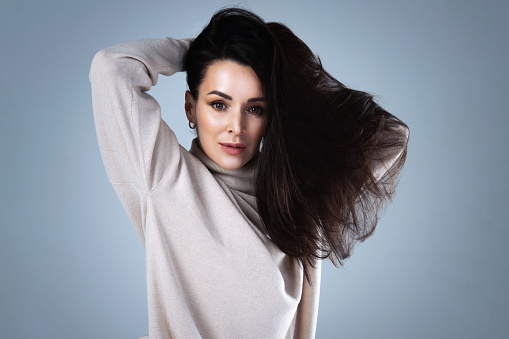 Studio portrait of a stylish young woman wearing a turtleneck jumper.