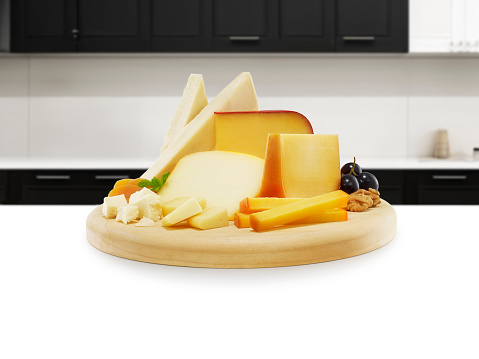 Cheese plate full of delicatessen on a kitchen island inside of a domestic kitchen