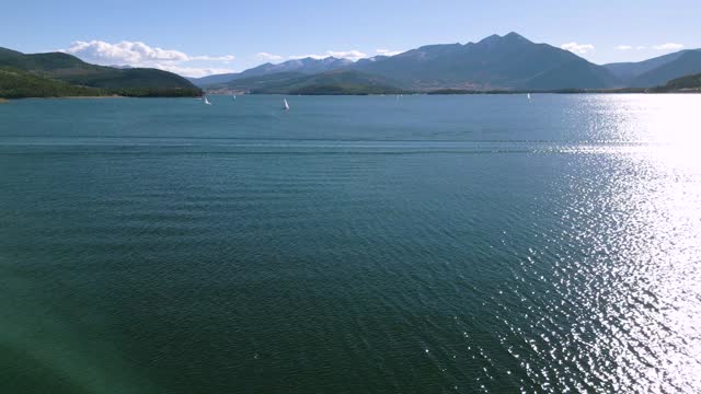 Drone footage of speedboat and sailboats on the lake of Dillon Reservoir in Colorado, USA