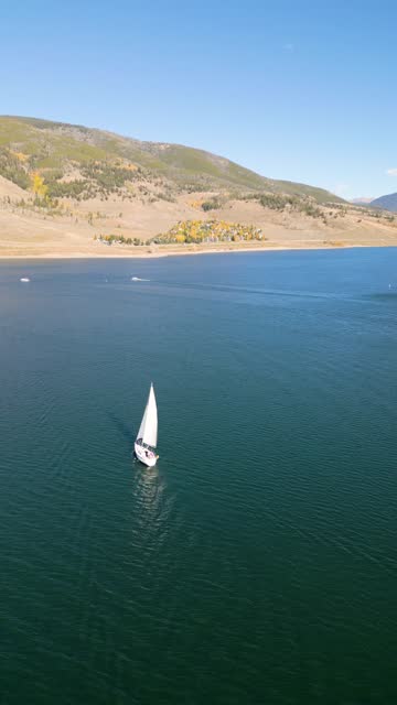 Drone footage of sailboat sailing in the lake of Dillon Reservoir on a sunny day in Colorado, USA