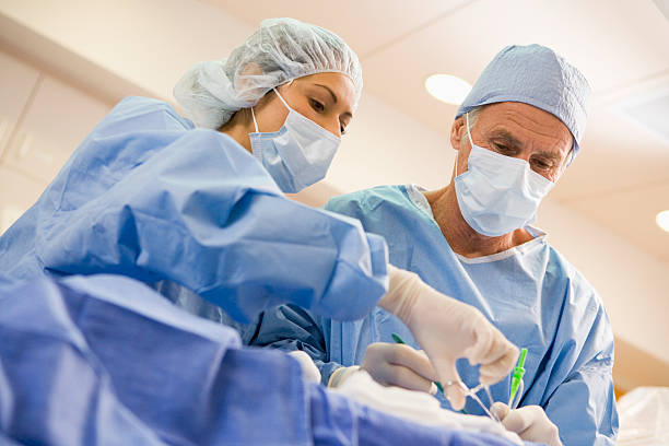 Surgeons Operating On Patient Surgeons Operating On Patient Concentrating heart surgery photos stock pictures, royalty-free photos & images