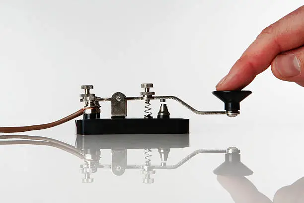 Photo of Person using a morse code machine on a white table