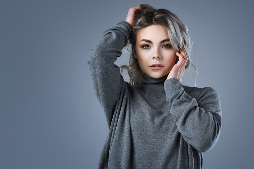 Studio portrait of a stylish young woman wearing a turtleneck jumper.