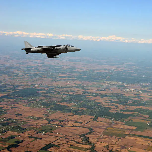 Jetfighter flying at high altitude above land