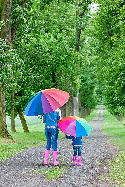 istock mother and daughter with umbrellas 177288691