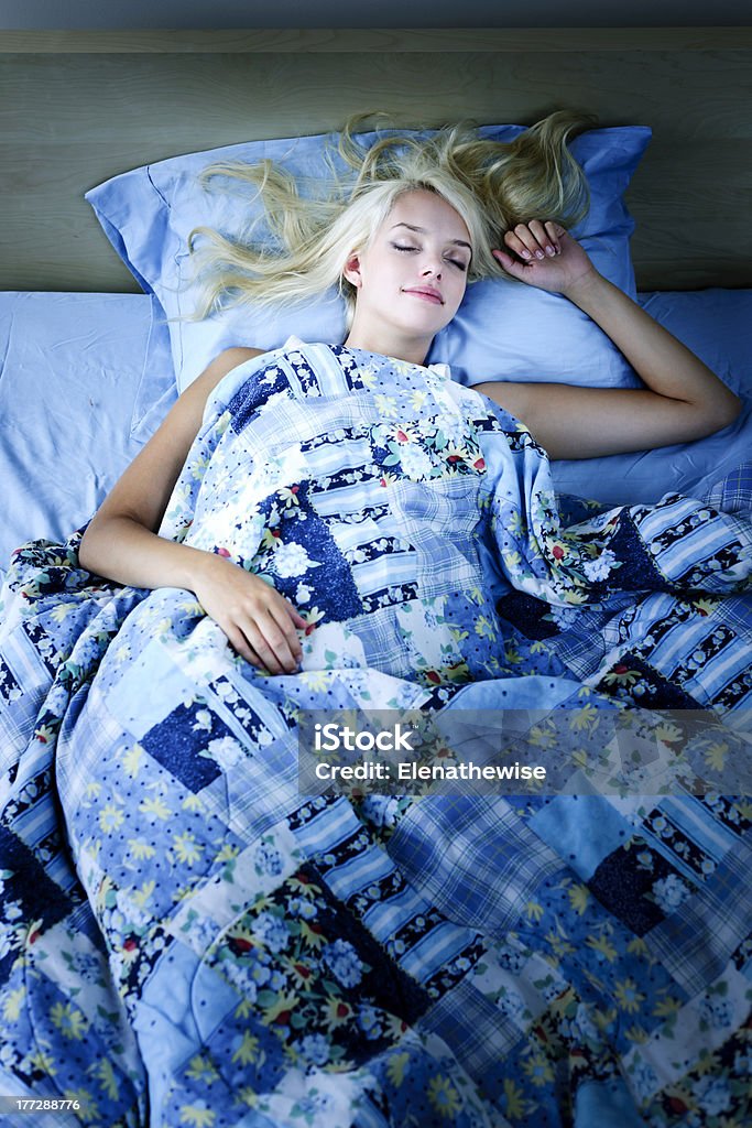 Woman sleeping in bed at night Young woman sleeping peacefully at night in bed Adult Stock Photo