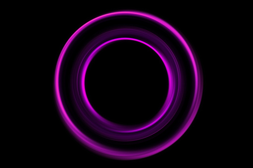 Circle of purple light, captured using long exposure, is isolated against a black background.