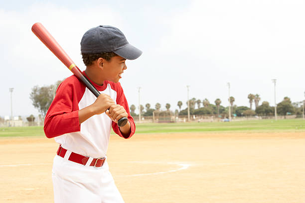 Little boy in baseball uniform practicing his swing Young Boy Playing Baseball In Park batting sports activity photos stock pictures, royalty-free photos & images