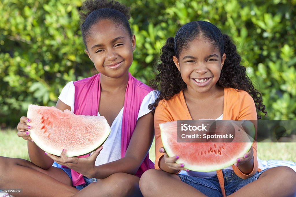 African American ragazza carina felice di bambini mangiando anguria - Foto stock royalty-free di Afro-americano