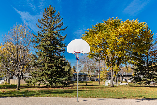 A netball hoop can be seen in a schoolyard. There are no people present in the image.