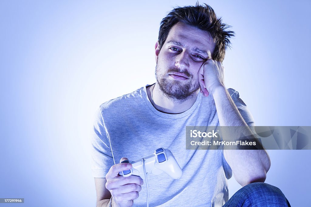 Annoiato uomo con Gamepad - Foto stock royalty-free di Console - Attrezzatura elettronica