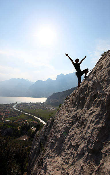 silhouette d'une femme de rock de montée d'escaliers et bras écartés - rock climbing mountain climbing women achievement photos et images de collection