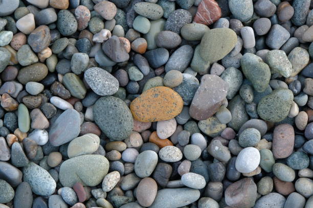 Ocean rocks background of washed stones piled on the beach at Wallabi Point, New South Wales, Australia