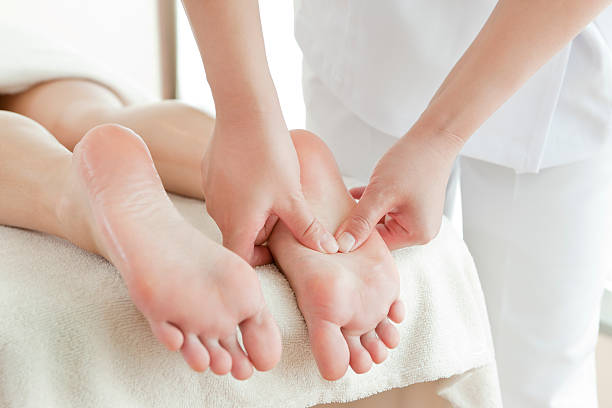 a mulher que recebe um tratamento de salão de beleza - human foot reflexology foot massage massaging - fotografias e filmes do acervo