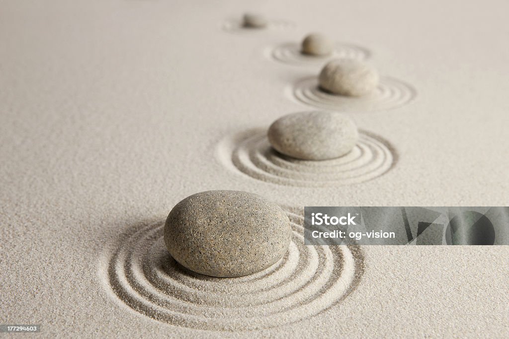 Stones in white stand with circles around them Stones on sand background Japanese Rock Garden Stock Photo