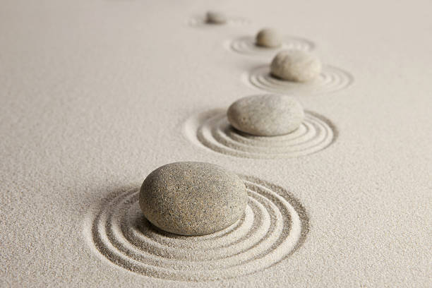 Stones in white stand with circles around them Stones on sand background japanese rock garden stock pictures, royalty-free photos & images