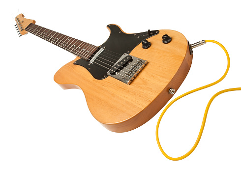 yellow electric guitar with a cable plugged against white background