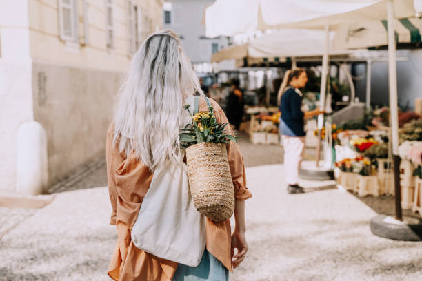 mulher jovem bonita comprando flores frescas no mercado do centro da cidade. mercado local de flores e alimentos. conceito de compras, pequenos negócios, produção sustentável. - built structure green business city - fotografias e filmes do acervo