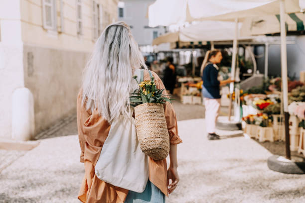 красивая молодая женщина покупает свежие цветы на рынке в центре города. местный цветочный и продовольственный рынок. концептуальный шопп� - built structure green business city стоковые фото и изображения