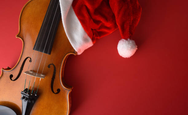 Violin body with Santa hat on a red background stock photo