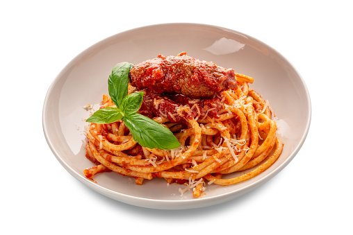 Bucatini pasta with meat rolls and tomato sauce and basil leaves and parmesan cheese in white plate isolated on white with clipping path included