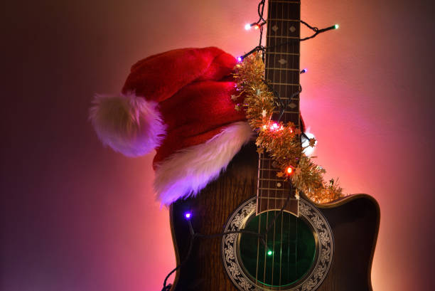 istock Guitar with hat and Christmas lights isolated with illuminated background 1772969970