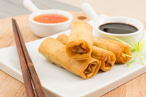 Springs rolls on white tray with chopsticks and sauces Fried duck spring rolls served with soy and sweet chili sauce. banchan stock pictures, royalty-free photos & images