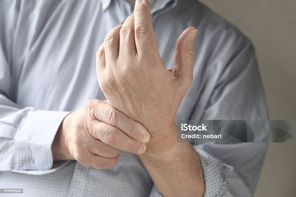 man has pain in wrist businessman checks the soreness in his wrist Beauty Stock Photo