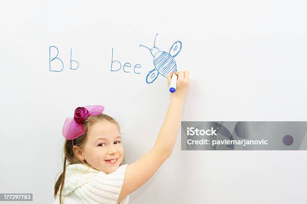 Sonriente Niña En Edad Escolar Aprender A Escribir Letra B Foto de stock y más banco de imágenes de Escribir