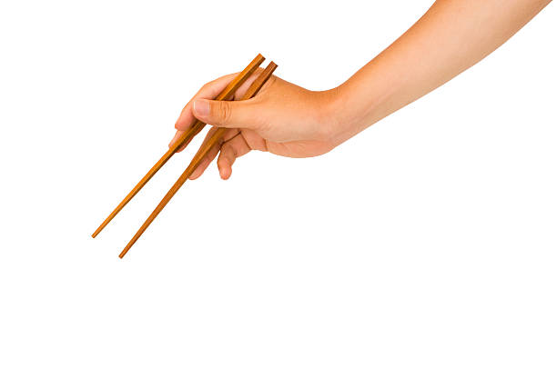 hand holding chopstick "isolated man hand holding wooden chopstick, with clipping path in jpg." chopsticks photos stock pictures, royalty-free photos & images