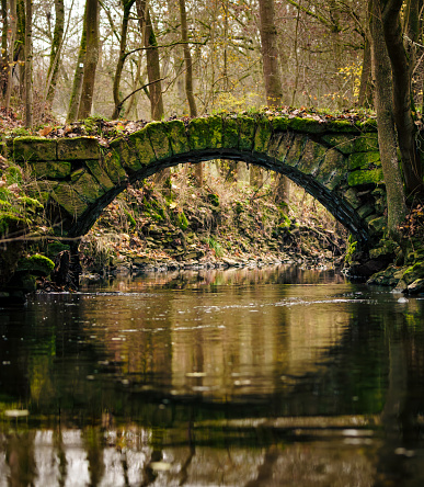 A small old stone bridge over a river in Germany.