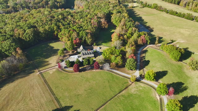 Big expensive residential house surrounded with farm fields and dense forest in rural North Carolina