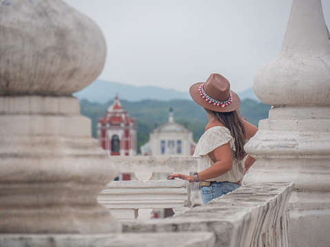 One woman sightseeing in Leon city, she stands on the rooftop of a church and look at the nature