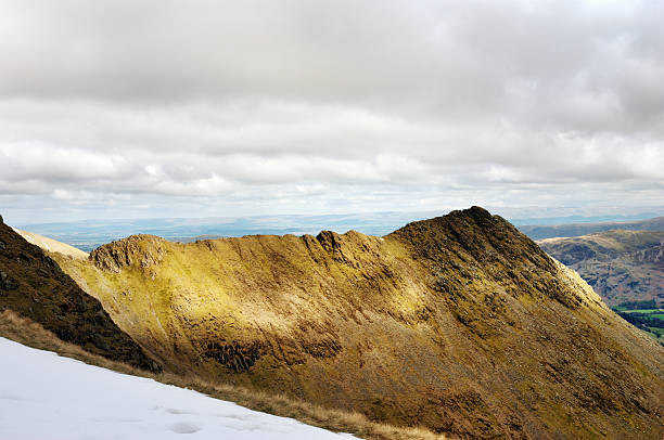 Sharp edged ridge leading to a peak Sharp edged ridge leading to a peak with a view toward the valley below striding edge stock pictures, royalty-free photos & images
