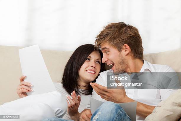 Couple Sitting On Couch At Home Stock Photo - Download Image Now - Mail, Couple - Relationship, Reading