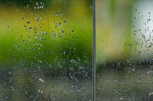 Rain falling on glass, textured background. Winter concept season
