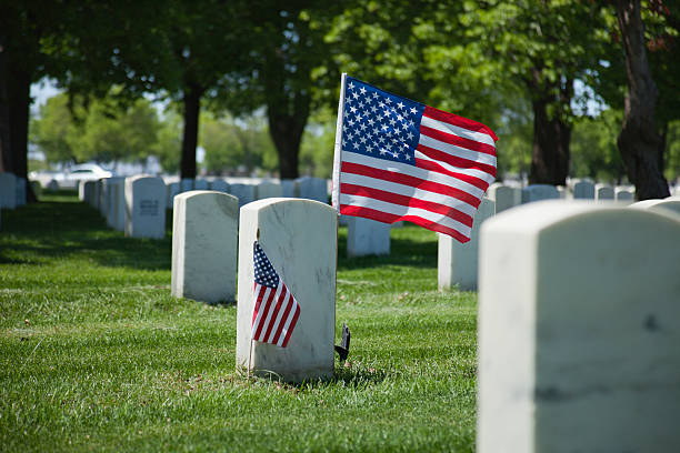 istock Military cemetery with US flags flying on tombstone 177299998