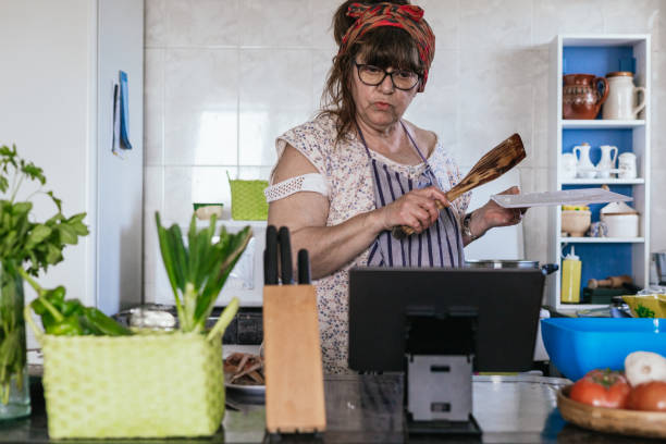 istock senior woman cooking while following the steps on an online streaming mobile device to copy a cook's recipe in her digital business. 1773001221