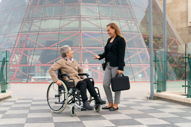 istock Two Female Employees, One of whom is Walking Disabled, Talking About Work During Lunch Break Outdoors 1773006799