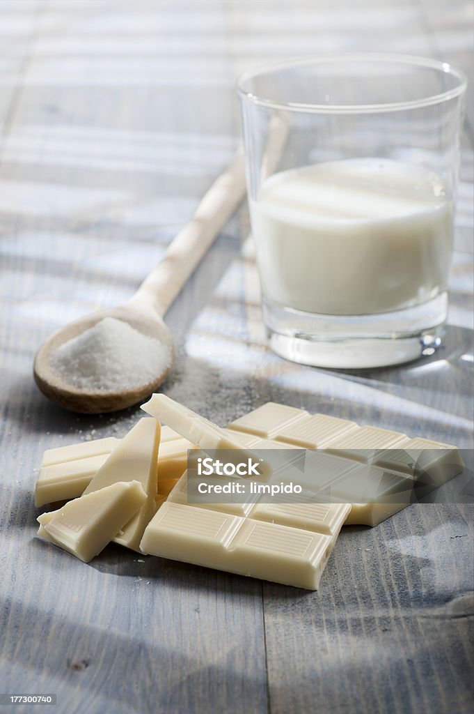 white chocolate "white chocolate bar with sugar and glass of milk, on wooden table lighted by the sun" Block Shape Stock Photo