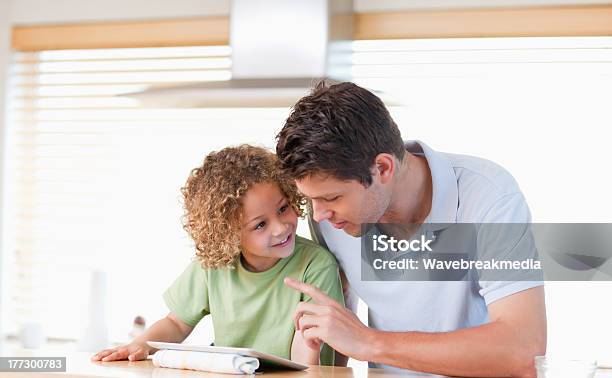 Photo libre de droit de Jeune Garçon Et Son Père À Laide Dune Tablette Ordinateur banque d'images et plus d'images libres de droit de Adulte